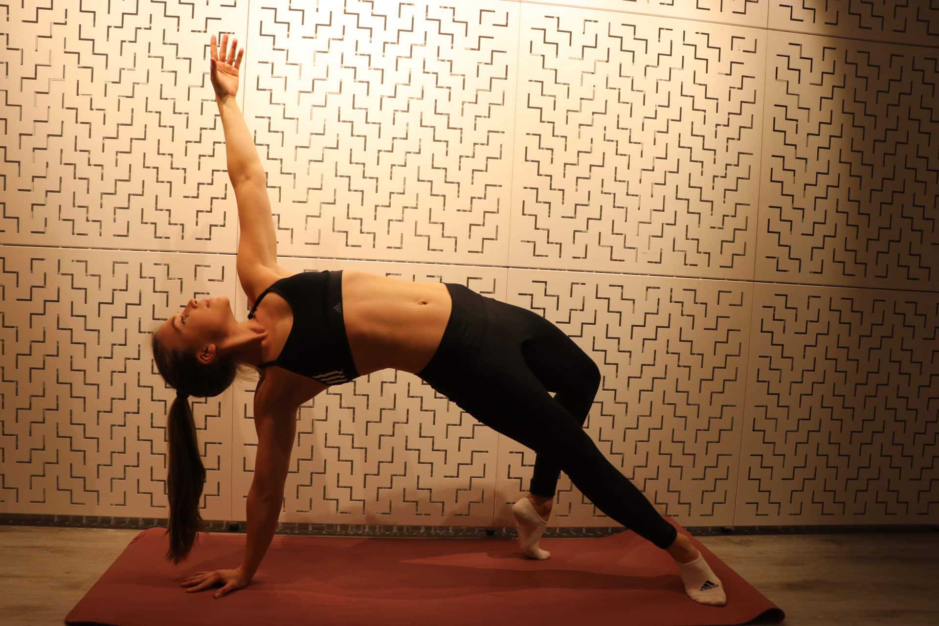 Coach Charlotte utför en sidosträckning i yoga